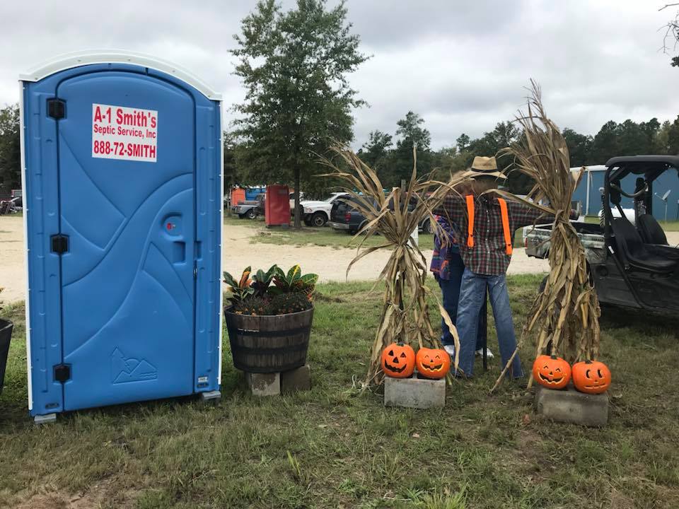 A-1 Smith's blue portable toilet rental at fall festival event with pumpkin decorations and scarecrow in East Texas community event